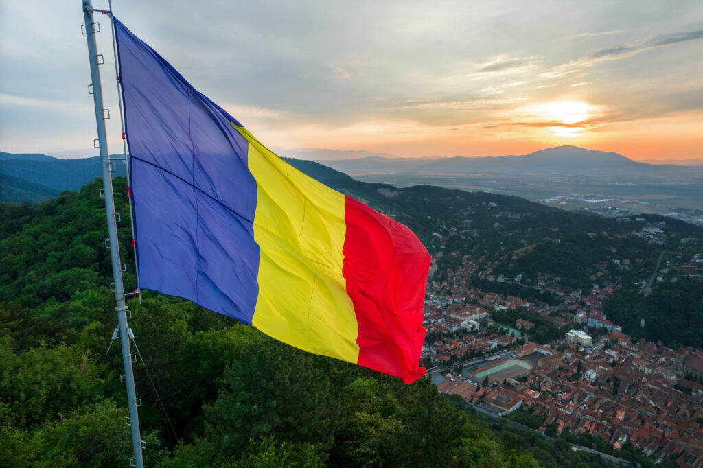national flag on the top of the hill in brasov at sunset, romania
