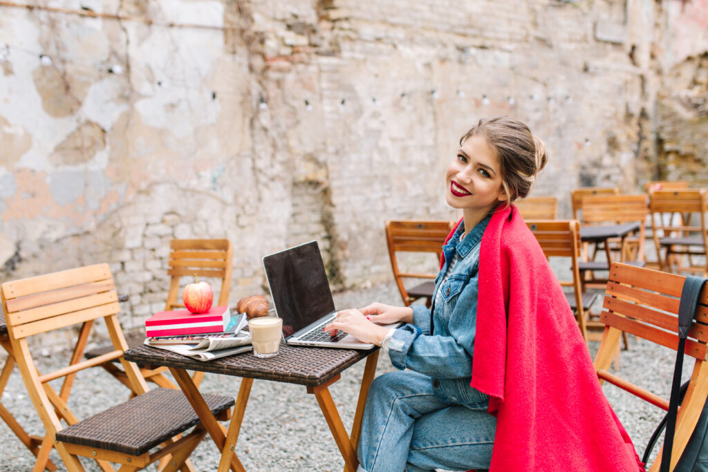 young buisnesswoman working on the new project using laptop during lunch time at the outdoor cafe. buisness lunch, internet distance work, freelance.